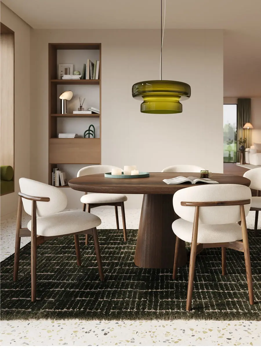 Chaise Piola avec structure en bois et assise rembourrée claire autour d’une table ronde en bois dans un intérieur moderne et chaleureux.