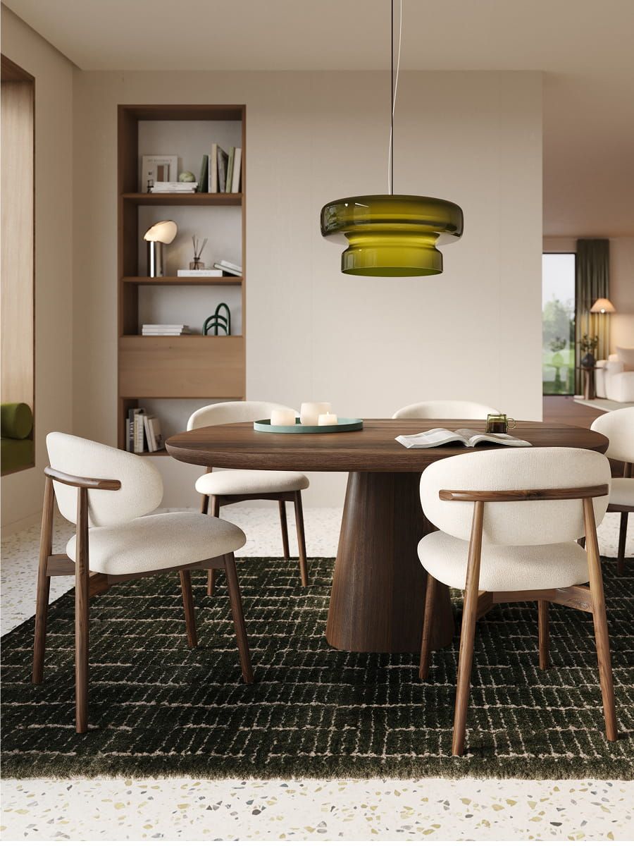 Piola stoel met houten frame en licht gestoffeerde zitting rond een ronde houten eettafel in een warm, modern interieur.