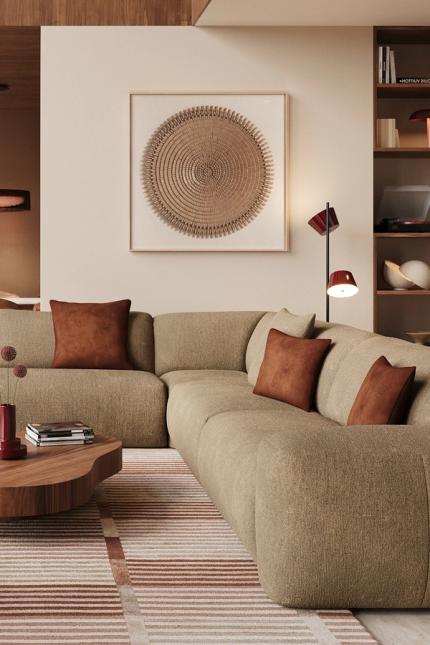 Sarpi hoekzetel in beige gemêleerde stof met roestbruine kussens, naast lage houten salontafel en wanddecoratie in warme woonkamer.