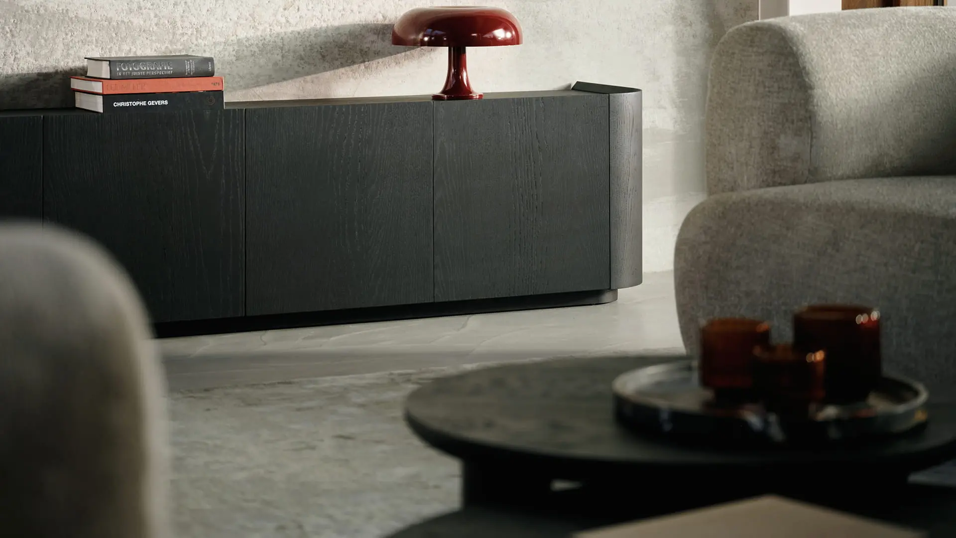 Buffet Rondato en bois foncé avec angles arrondis et façade épurée, placé dans un intérieur moderne avec une décoration subtile.