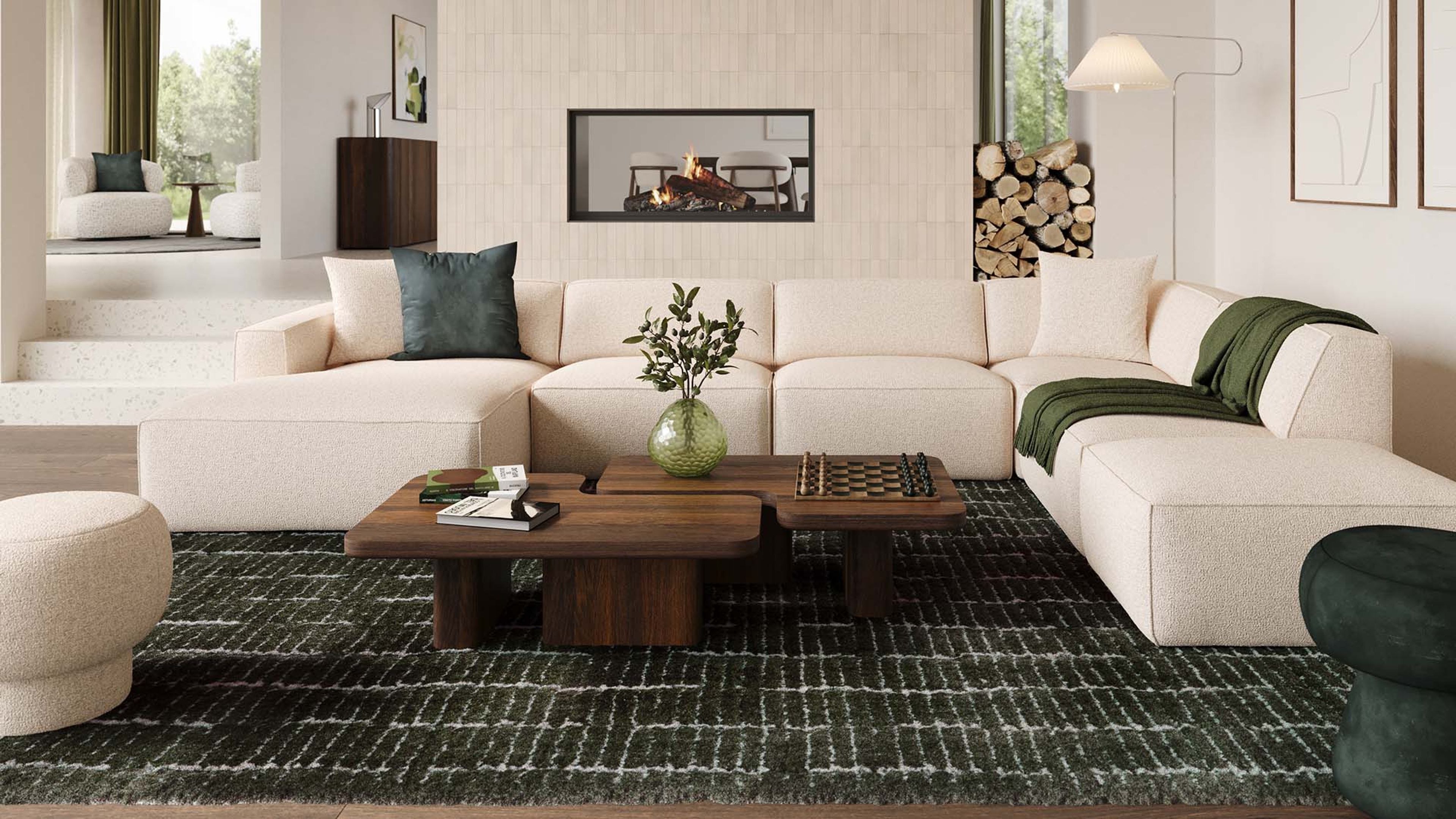 Beige hoekzetel Isola in lichte woonkamer met grote ramen, houten boekenkast, lage salontafel en zachte natuurlijke materialen.