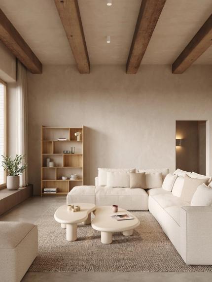 Table basse Artisano aux formes organiques en beige clair sur un tapis dans un intérieur chaleureux avec canapé et étagère.