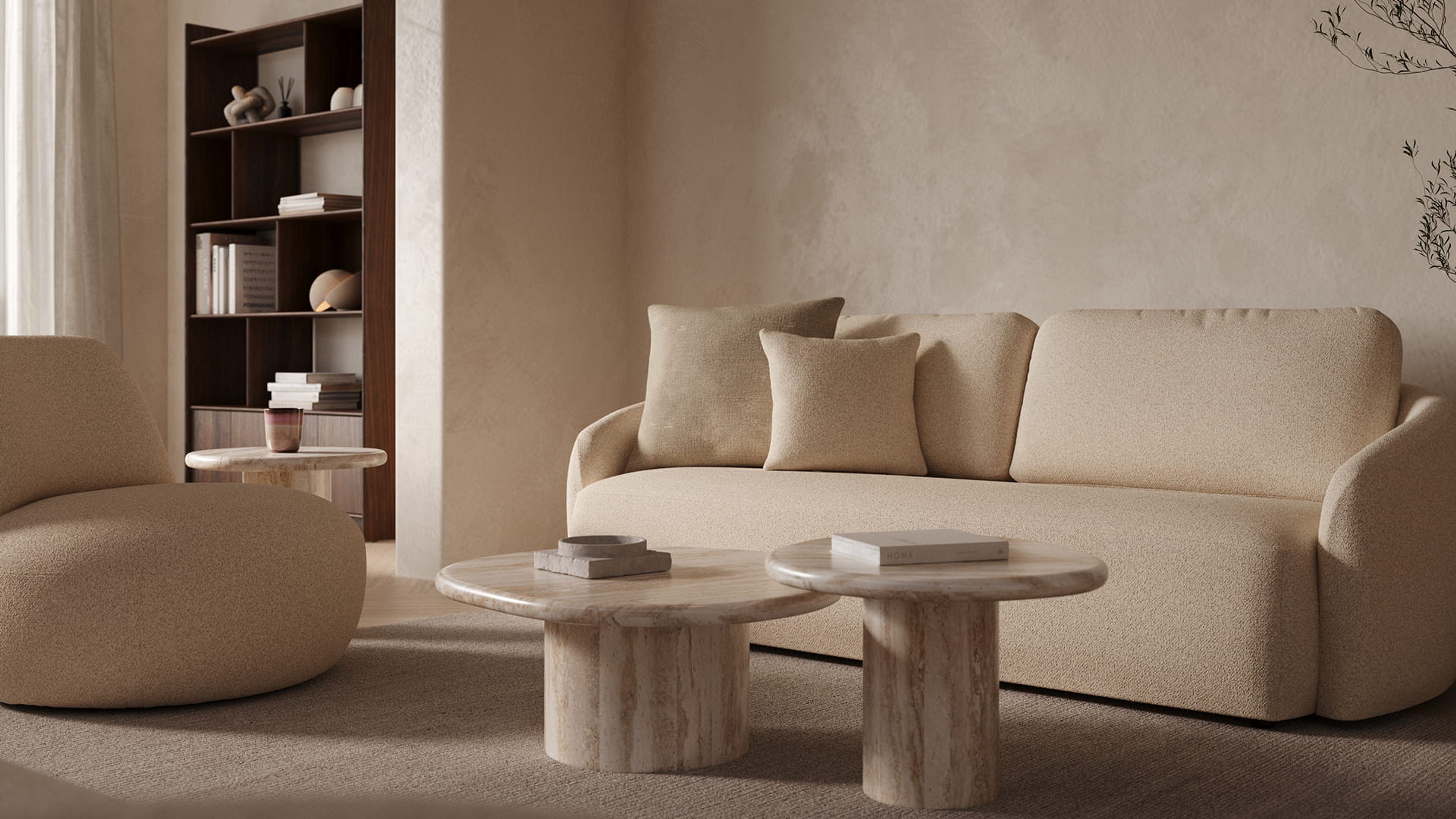 Gatto fauteuil in licht bouclé stof in een warme woonkamer, naast een beige sofa en twee ronde marmeren salontafels op een groot vloerkleed.