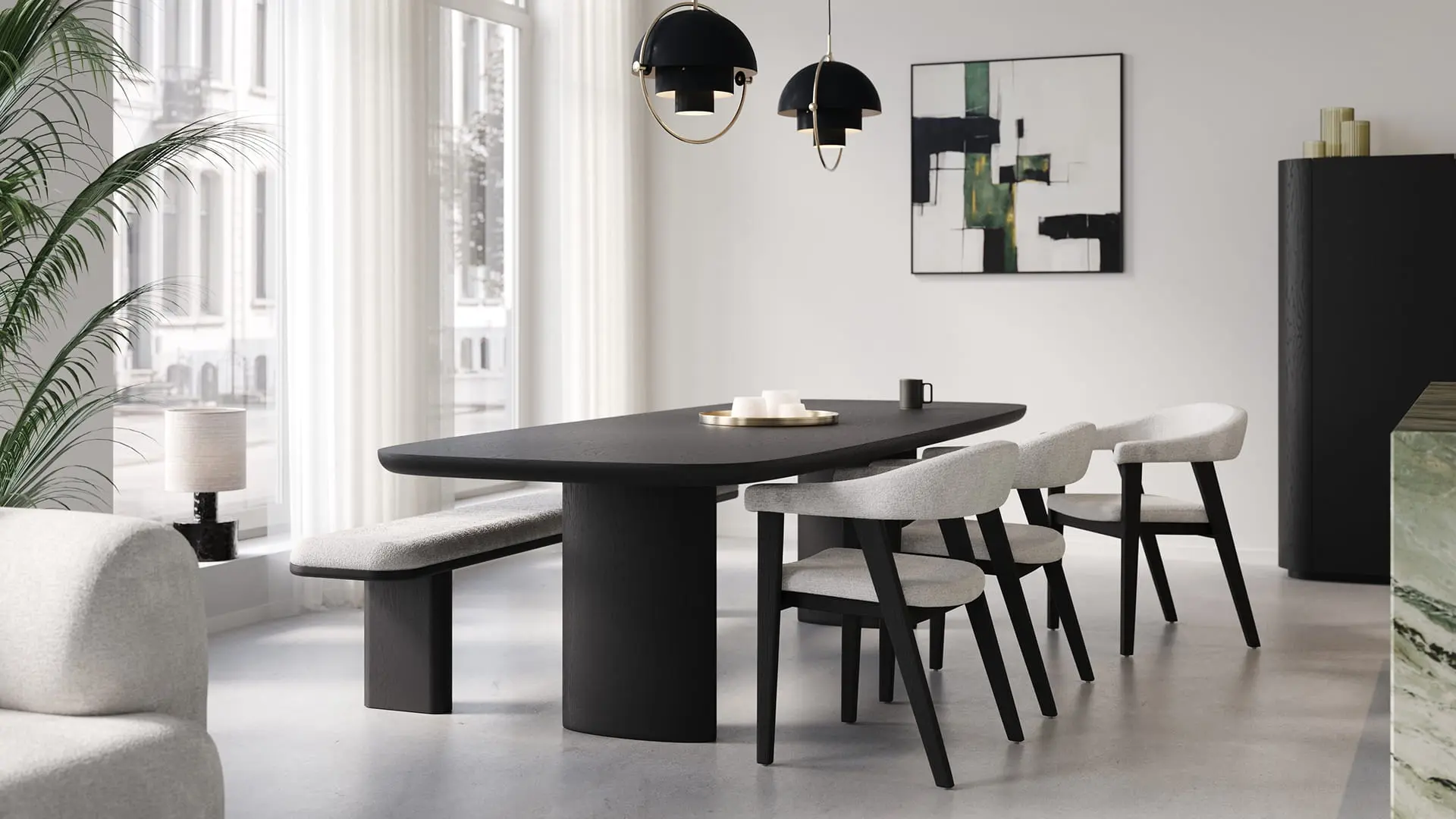 Lange zwarte Amato eettafel met afgeronde hoeken, met lichte stoelen en bank in een rustige, lichte eetkamer.