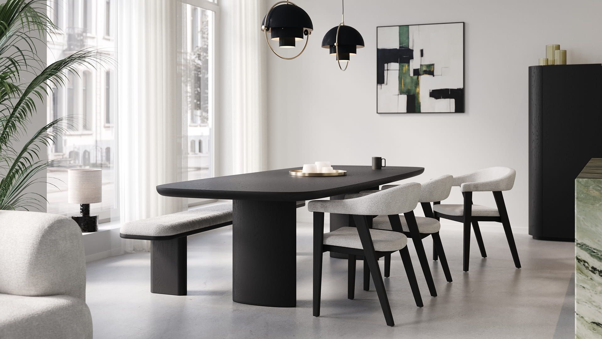 Lange zwarte Amato eettafel met afgeronde hoeken, met lichte stoelen en bank in een rustige, lichte eetkamer.