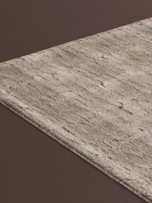Close-up van een beige tapijt met subtiel gemêleerd patroon en zachte, geweven textuur.