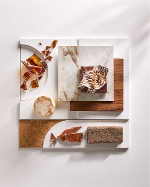 Moodboard met stalen van natuursteen, hout, kurk, geweven stof en glas in warme aardetinten.