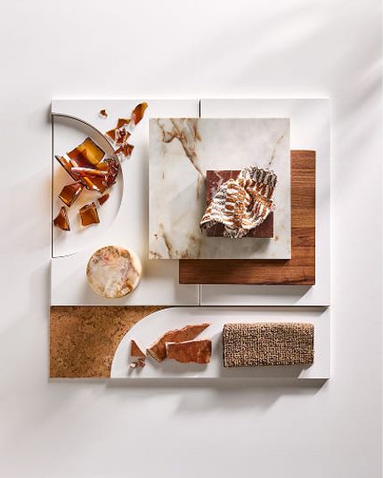 Moodboard met stalen van natuursteen, hout, kurk, geweven stof en glas in warme aardetinten.