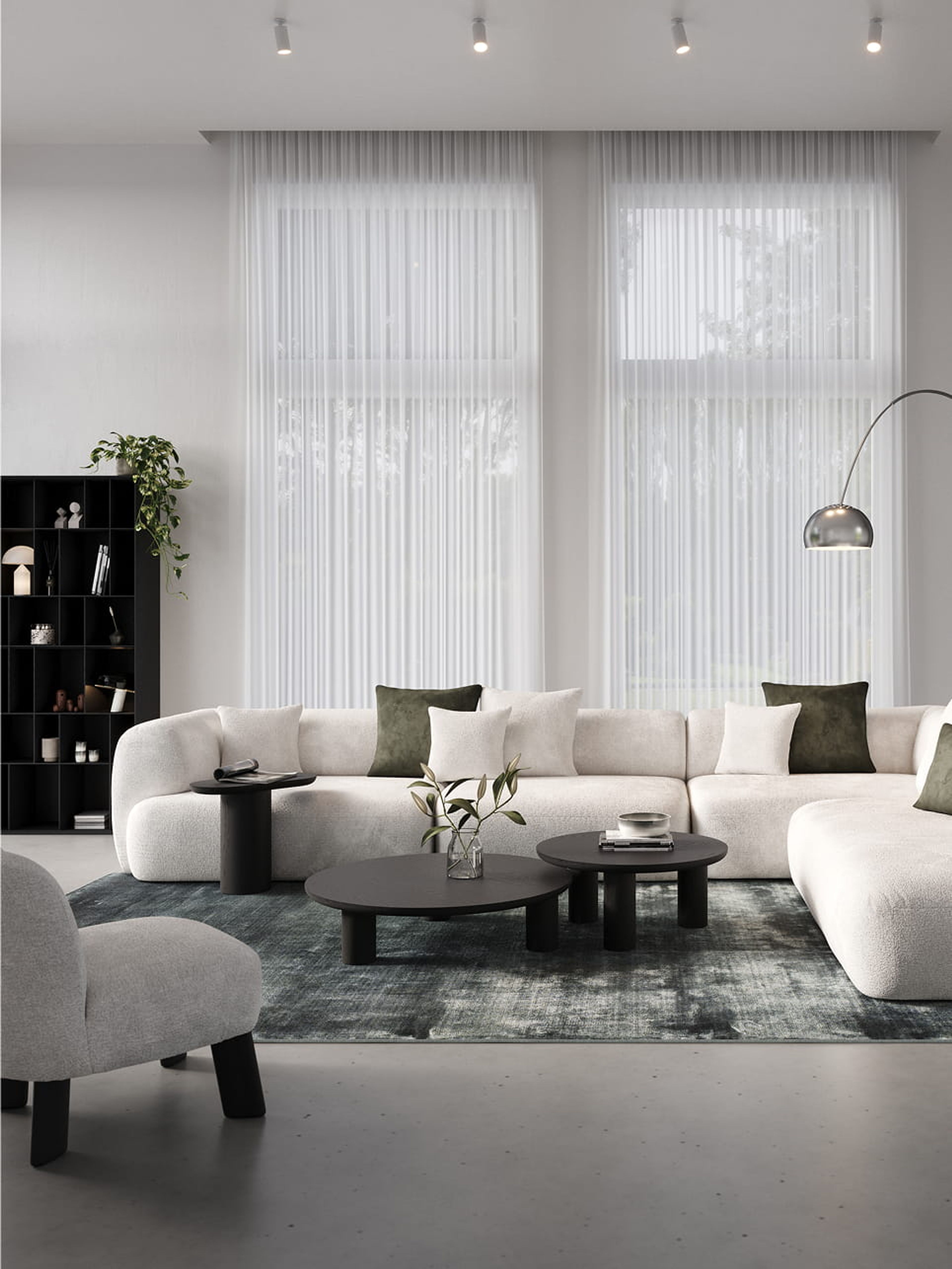 Table basse Amato ronde noire sur un tapis devant un canapé modulable beige dans un intérieur moderne.