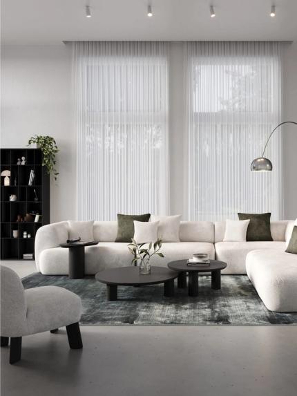 Artisano ronde salontafel in zwart op een tapijt voor een modulaire beige zetel in een modern interieur.