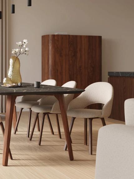 Donkere eettafel met marmeren blad en houten poten, omringd door licht gestoffeerde stoelen in een warme, minimalistische eetruimte.