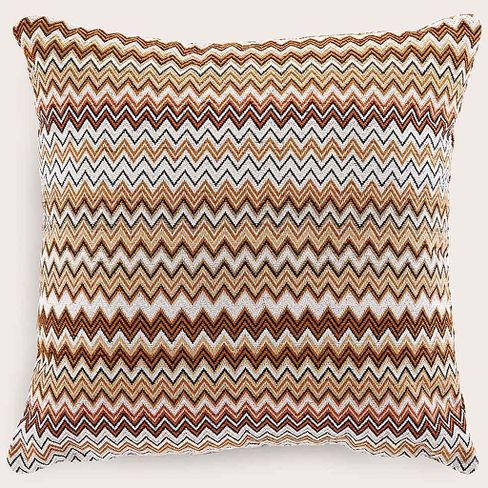 Coussin décoratif carré avec motif zigzag en cuivre, ocre, noir et blanc, sur tissu tissé.