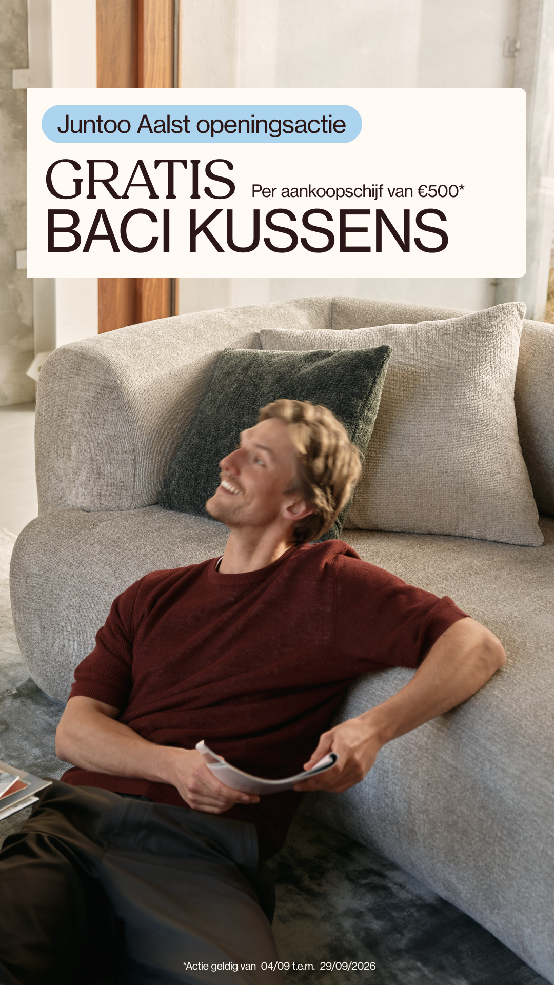 Houten tafel met decoratieve kussens, marmeren accessoires en een boekenkast.
