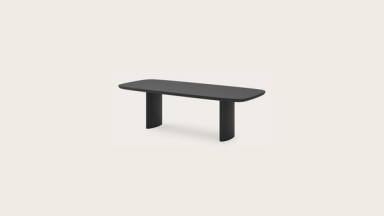 Zwarte Amato-tafel met afgerond rechthoekig blad en twee brede poten, vrijstaand.