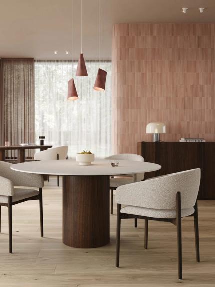 Comino stoelen in lichtbeige stof rond ronde eettafel met donker onderstel, in zachte roze eetkamer.