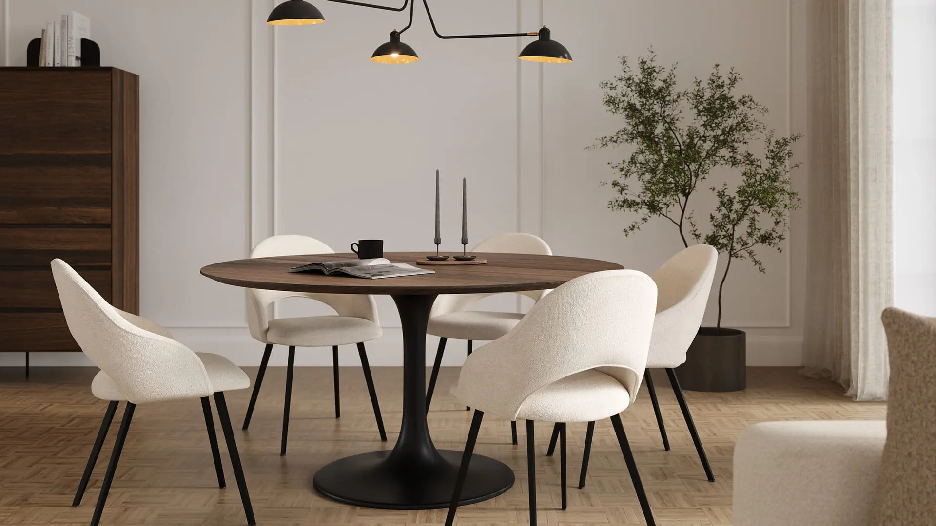 Coin repas avec table ronde en bois et quatre chaises Grado en tissu clair avec pieds noirs, sous une suspension noire.
