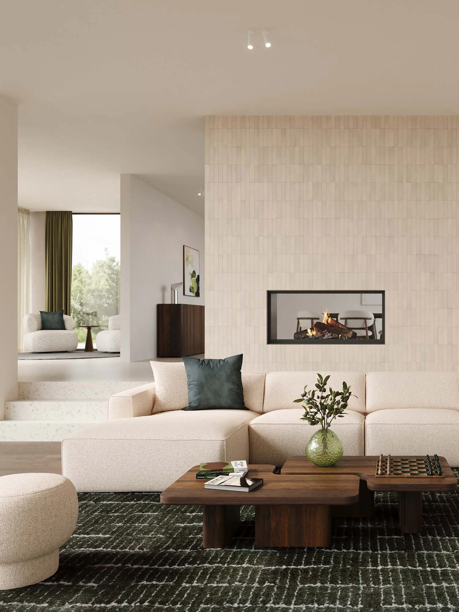 Beige hoekzetel Isola in lichte woonkamer met grote ramen, houten boekenkast, lage salontafel en zachte natuurlijke materialen.