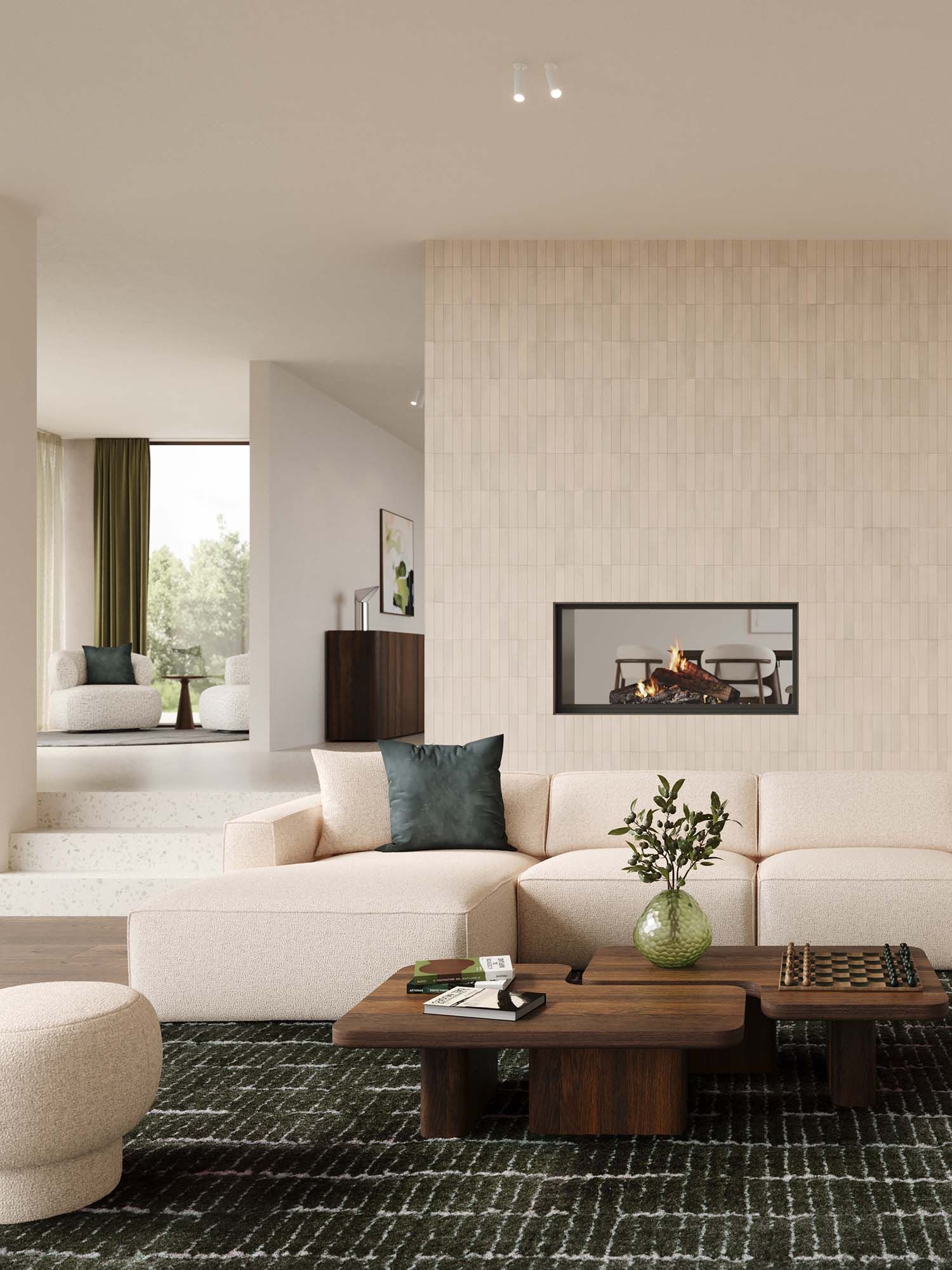 Beige hoekzetel Isola in lichte woonkamer met grote ramen, houten boekenkast, lage salontafel en zachte natuurlijke materialen.