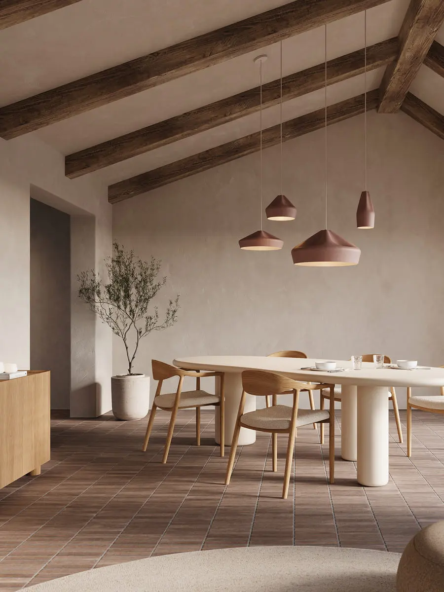 Salle à manger avec table ovale et chaises Padua au revêtement clair, sous des poutres en bois et des suspensions dans un intérieur naturel et chaleureux.