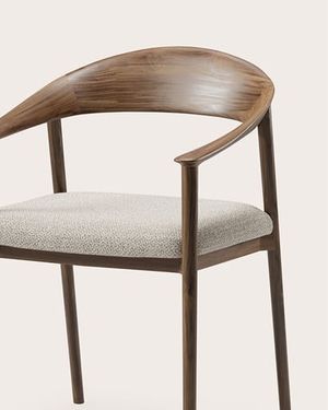 Detail van een eetkamerstoel met gebogen rugleuning in donker hout en een licht gestoffeerde zitting.