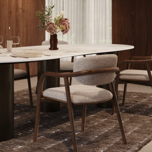 Eetkamer met organische eettafel, gestoffeerde houten stoelen en bloemstuk tegen een warme houten wand.