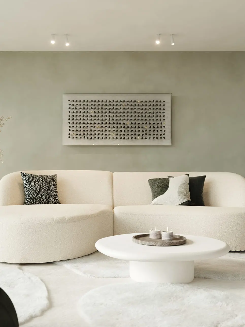 Table basse Artisano en forme de galet blanche devant un canapé beige dans un intérieur moderne et apaisant.