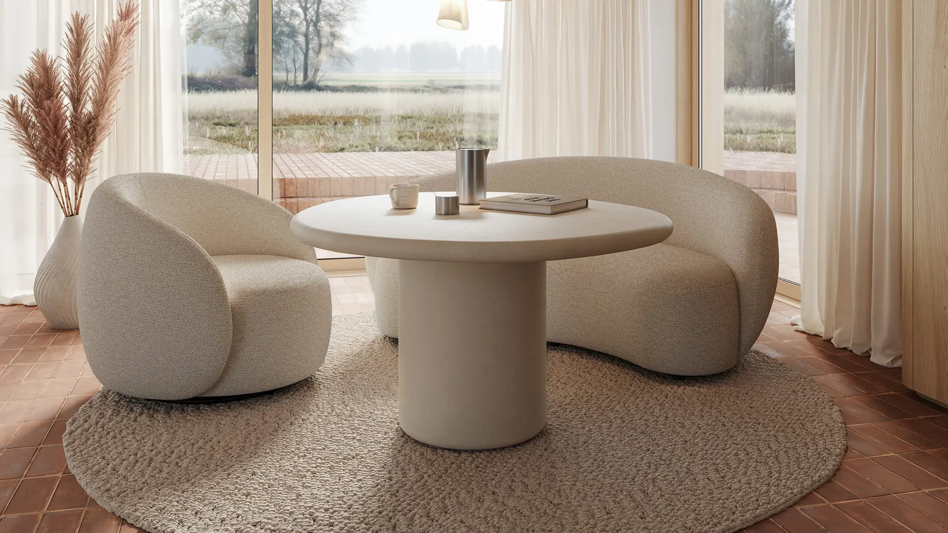 Canapé Ponte beige aux formes arrondies autour d’une table à manger ronde dans un espace lumineux avec grandes fenêtres et vue sur la nature.